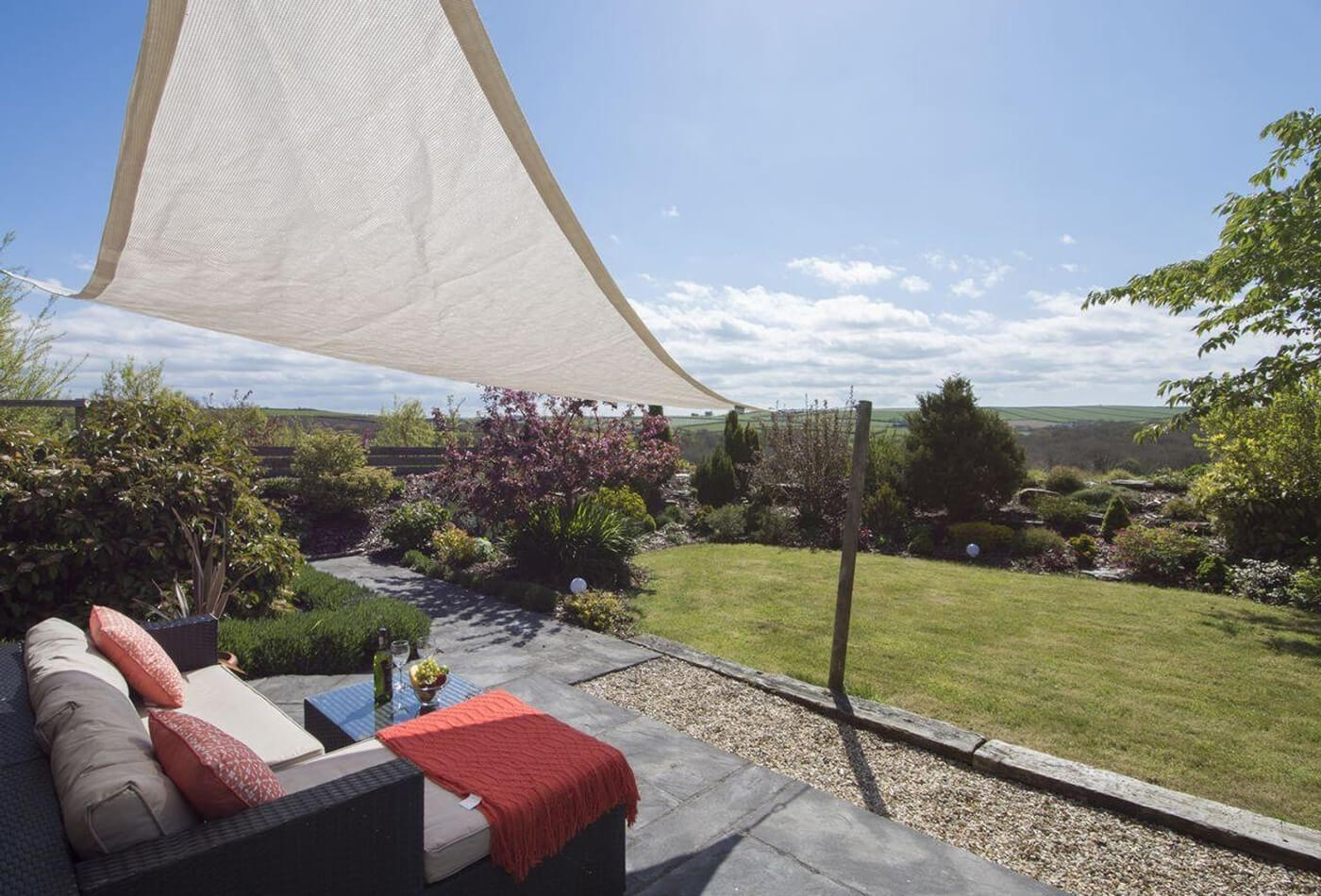 A 5 star luxury cottage with sunshade sail, patio furniture and rolling hill views.