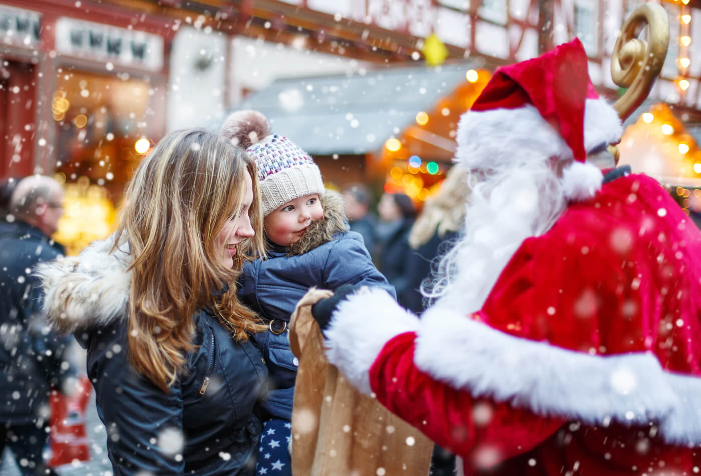 Mother and child at a Christmas market meeting Santa in Devon.