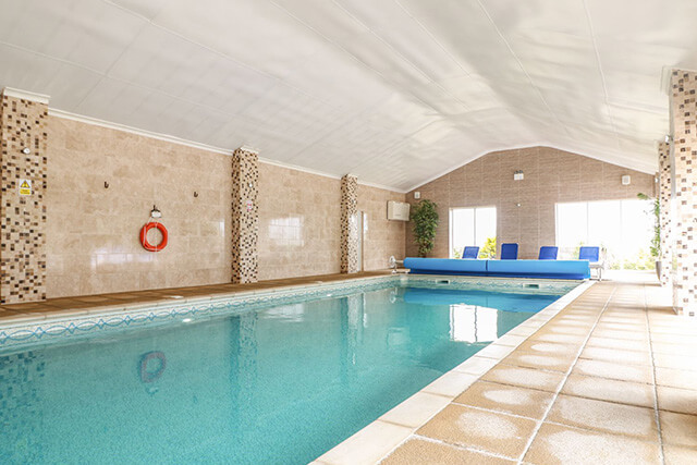 Swimming pool maintenance - indoor pool with life ring and pool cover.