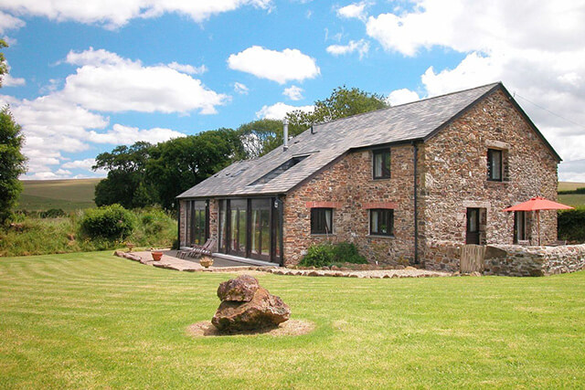 The Red Barn holiday cottage - building with green lawn.