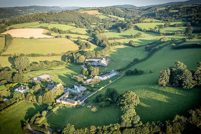 Aerial view of maple cottage and the rolling countryside.