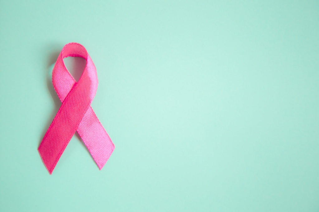 Pink Breast Cancer Awareness ribbon on green background