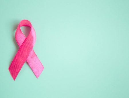 Pink Breast Cancer Awareness ribbon on green background