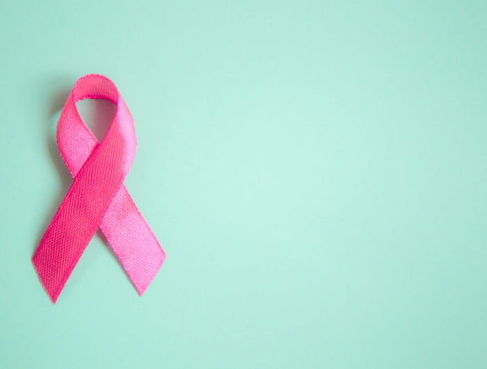 Pink Breast Cancer Awareness ribbon on green background