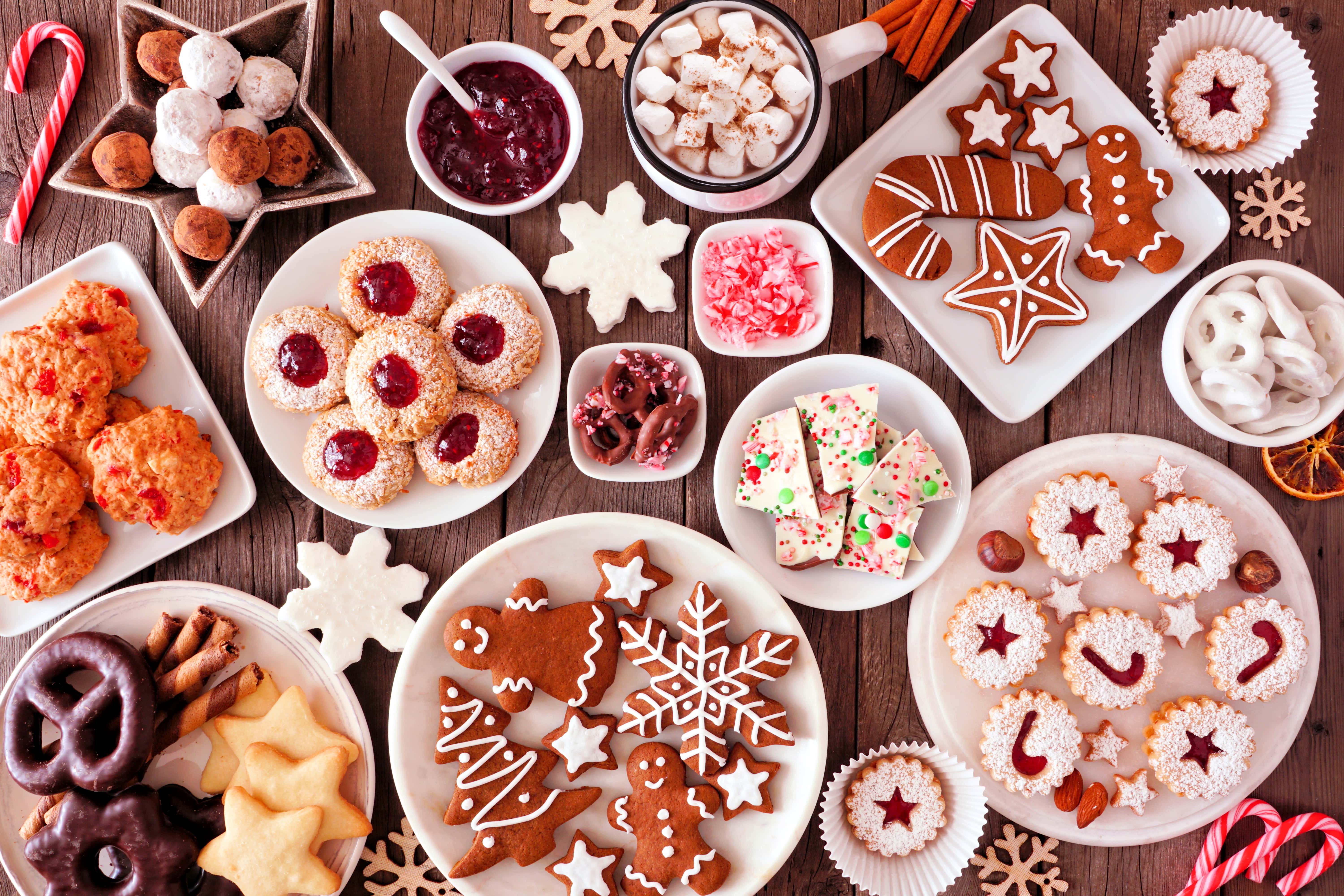 Christmas-baking-table-scene-with-assorted-sweets-and-cookies,-top-view-over-a-rustic-wood-background