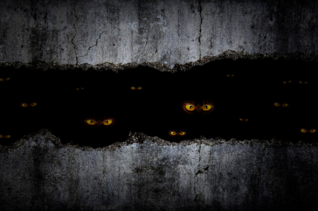 scary-eyes-between-grungy-cracked-and-broken-concrete-wall-in-the-dark