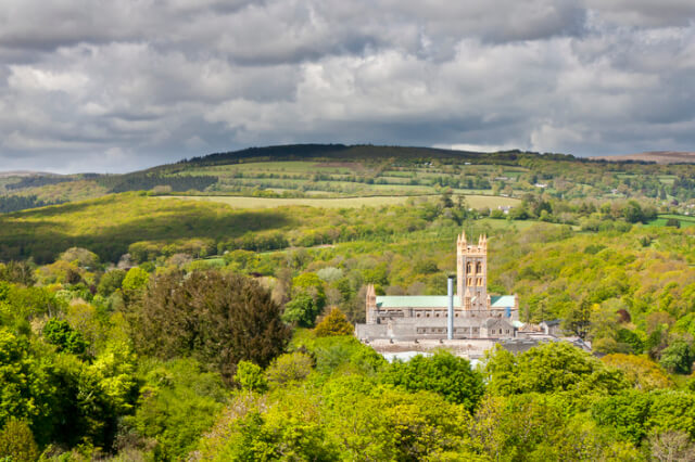 A view of Buckfast Abbey from afar amidst the Dartmoor landscape.