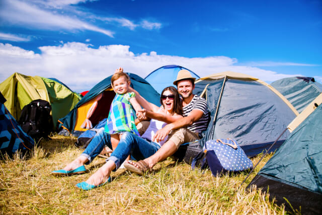 Parents in a camping field with a baby.