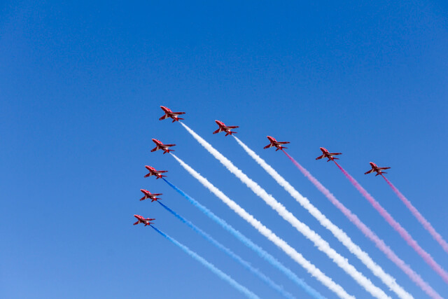 Red Arrows flying across a blue sky.