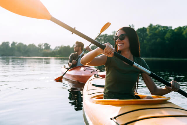 Two adults kayaking on a lake.