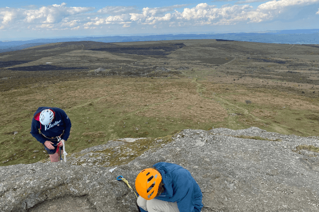 Climbers setting up their protection on High Man, Haytor in Dartmoor.