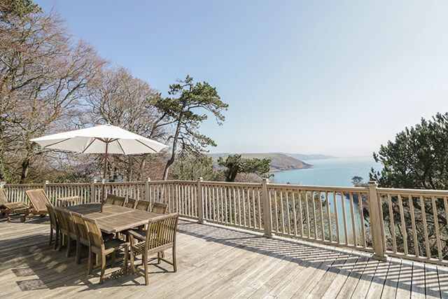 decked terrace with patio furniture overlooking the sea in Salcombe.