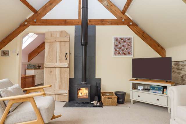 Cosy lounge with a wood burner in the centre and a large television beside it
