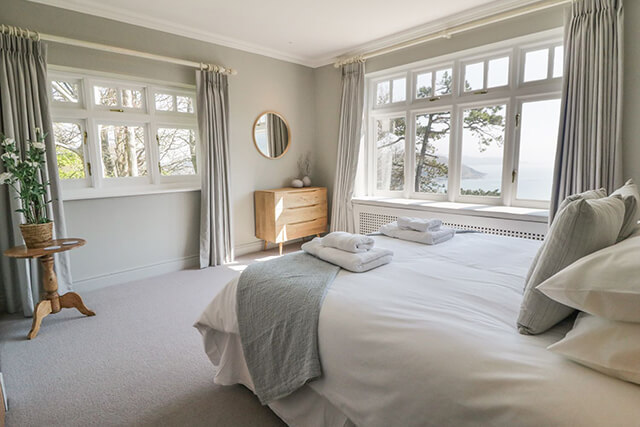 bedroom with bed, curtains and seaview - all prepped after holiday let changeover.