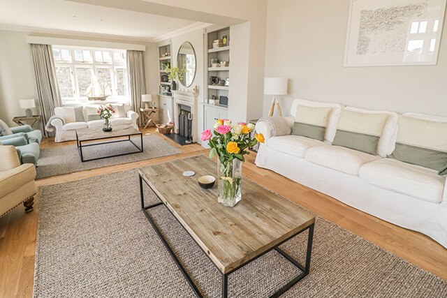 living area with sofas, open fire and fresh bouquet of flowers.