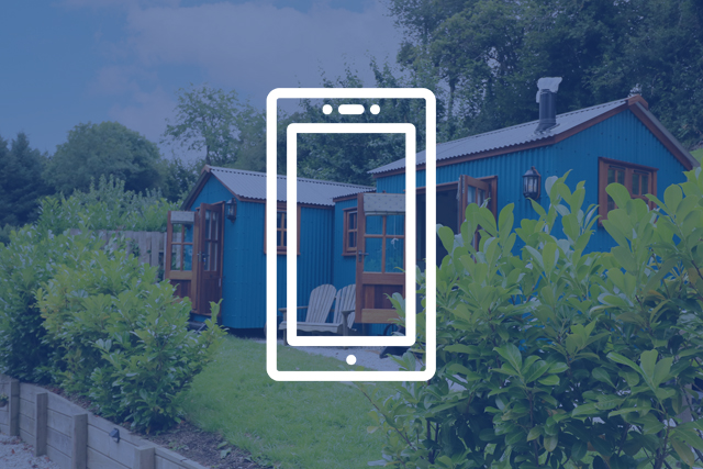 South West Holiday Let Marketing and Advertising Tips: Mobile phone icon overlaid on an image of a shepherd's hut