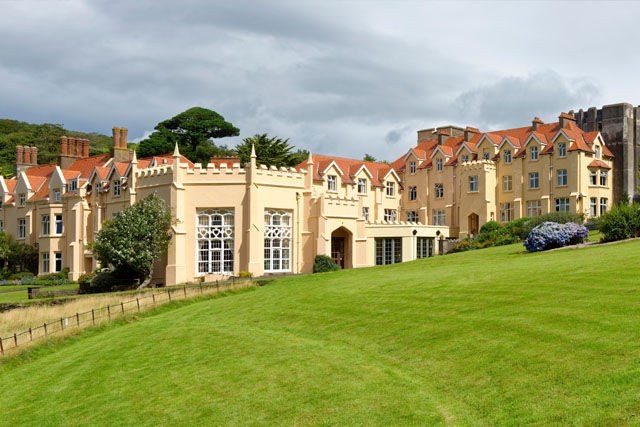 The Gothic-style building of Lee Abbey, with lush green lawn in the foreground