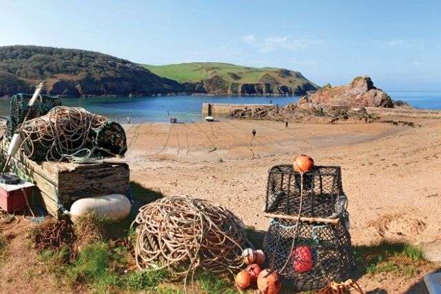 Hope cove beach with crabbing and lobster fish baskets in foreground